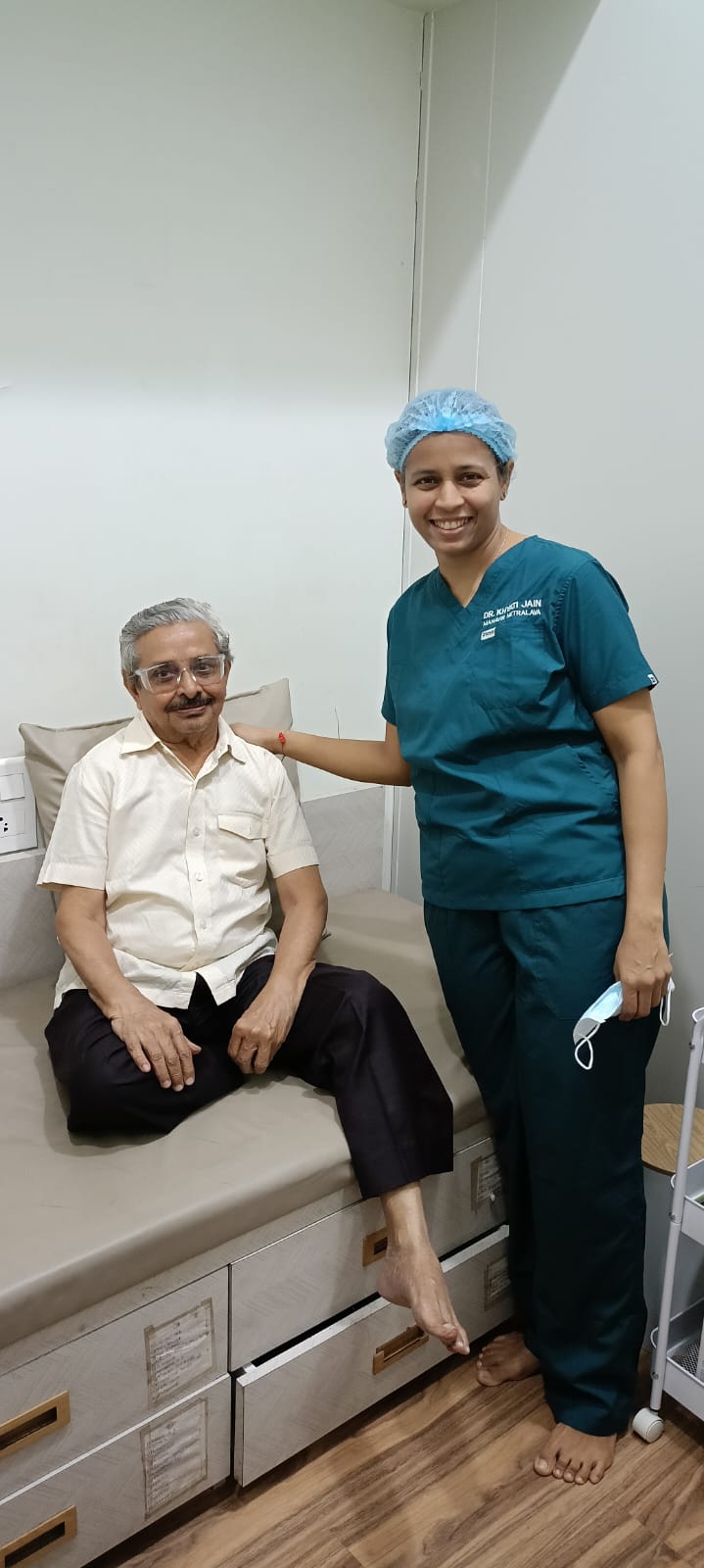 Doctor in surgical scrubs standing with a patient