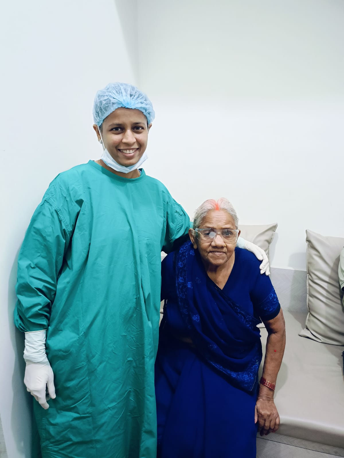 Doctor in surgical gown standing with an elderly patient